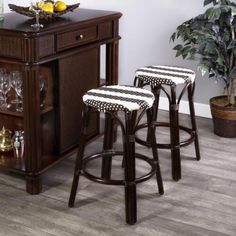 three bar stools sitting in front of a wooden cabinet