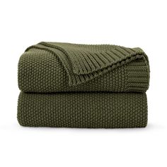 the green blanket is folded on top of each other