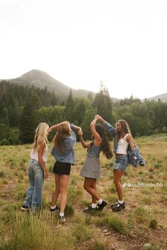 three girls are standing in a field with their arms around each other