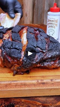 someone cutting up a piece of meat on top of a wooden board