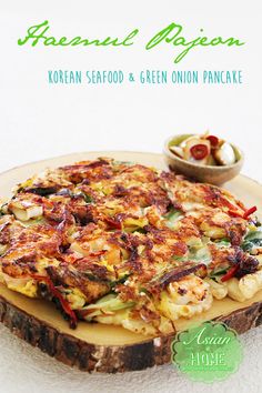 a plate with some food on it and a bowl in the background that says, korean seafood & green onion pancake