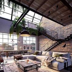 a living room filled with furniture next to a brick wall covered in plants and greenery