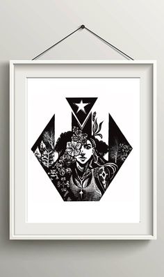 a black and white print hanging on the wall next to a framed frame with an image of a woman's face