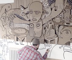 a man is drawing on the wall with his hands