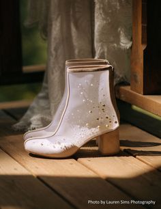 a pair of white boots sitting on top of a wooden floor