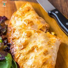 a wooden cutting board with some food on it and a knife next to the pizza