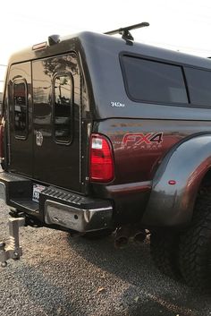 the back end of a black truck parked in a parking lot