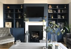 a living room filled with furniture and a flat screen tv mounted on a wall above a fire place