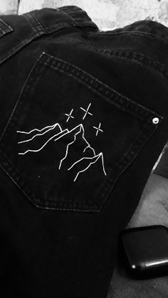 a pair of black jeans with white mountains on them