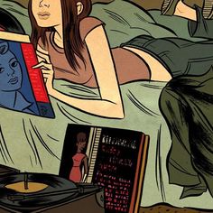 a woman laying in bed next to a record player