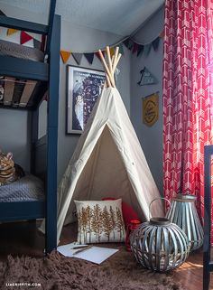 a teepee tent in the corner of a room with curtains and pillows on the floor