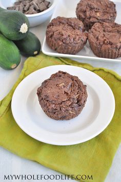 chocolate muffins on a white plate next to bowls of avocado and zucchini