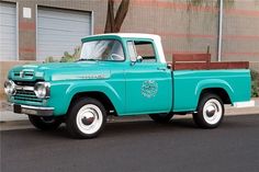 an old blue truck parked in front of a building