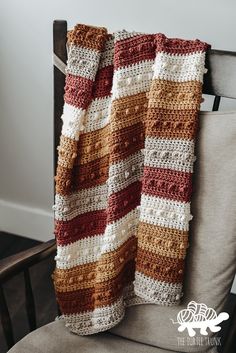 a crocheted blanket sitting on top of a chair