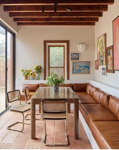 a living room with couches, tables and pictures hanging on the wall above them