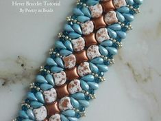 a blue and white beaded bracelet with hearts on it's side, sitting on a marble surface