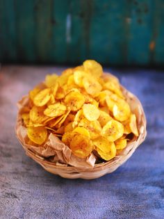 a basket full of dried bananas sitting on top of a blue cloth covered tablecloth