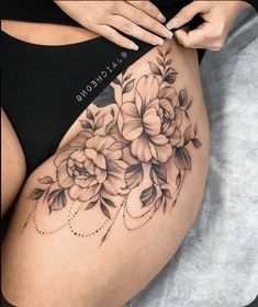 a woman's stomach with flowers on it and the word tattoo written in black ink