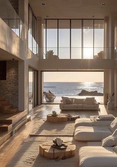 a living room with white furniture and large windows overlooking the ocean in front of it