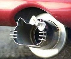 the tail end of a red car with a cat shaped exhaust pipe