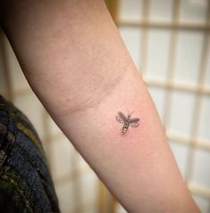 a small tattoo on the arm of a woman with a dragonfly tattooed on it