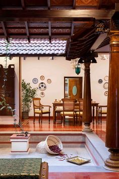 a living room filled with furniture next to a wooden table and two vases on the floor