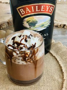 a bottle of bailey's irish coffee next to a glass with ice cream on it