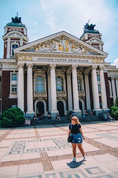 a woman standing in front of a large building