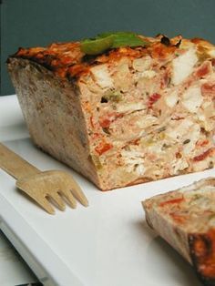 a piece of food sitting on top of a white plate next to a fork and knife