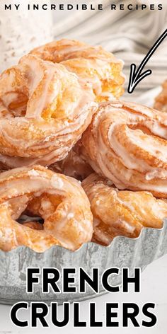 a bunch of doughnuts sitting on top of a pan with the words french crullers