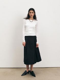 This Tucked A-Line Skirt is a classic piece with a modern twist, offering a flattering silhouette with its high waist and flowing A-line shape. The skirt boasts elegant tucks that add volume and a touch of sophistication, making it a versatile addition to any wardrobe. The skirt's midi length ensures it is appropriate for a range of occasions, from office wear to casual outings. - High-waisted design accentuates the figure and provides a base for tucked-in or cropped tops.- Strategic tucks around the skirt add a refined volume, enhancing the A-line shape and creating a timeless look.- Midi length offers versatility in styling, pairing well with both flats and heels depending on the desired look.- The skirt's cut and style make it a year-round staple, suitable for layering in colder mo Chic Asymmetrical Skirt With Pleated Hem, Chic Bottoms With Folds For Spring, Fitted Flared Maxi Skirt With Pleated Waist, Chic Folded Skirt For Workwear, Fitted Maxi Skirt With Pleated Waist, Spring Flared Maxi Skirt With Folds, Fitted Bottoms With Folds For Spring, Spring Full Skirt With Folds, Classic Spring Midi Pleated Skirt