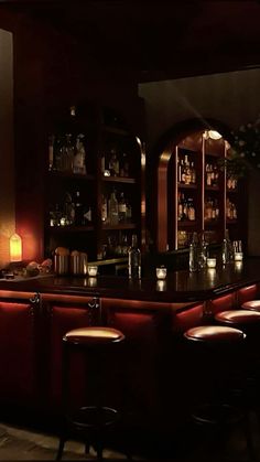 a dimly lit bar with stools in front of it