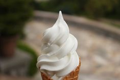 an ice cream sundae with whipped cream on top is sitting on a table outside