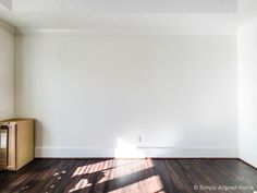 an empty room with hard wood floors and white walls