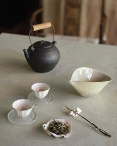 an assortment of teacups and saucers on a table