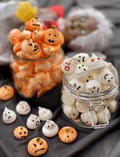 there are many halloween candies in the glass jar and on the table next to each other