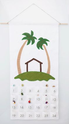 a calendar hanging on the wall with a house and palm trees in front of it