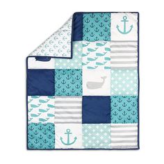 a blue and white quilted blanket with an anchor, whale, and anchors on it