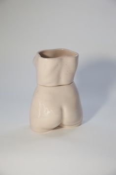 a white vase sitting on top of a table