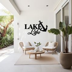 a living room with two chairs and a coffee table in front of a wall that says lake life