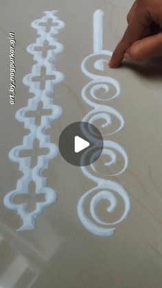 someone is drawing on a piece of paper with white paint