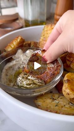 a person dipping some food into a bowl