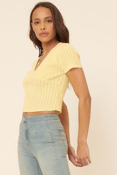 Ribbed pointelle knit top. Deep V neckline. Short sleeves. Scalloped edge at neckline, cuffs, and hem. Cropped length. Fitted silhouette. 70% Cotton, 30% Nylon. Imported. Designed in Los Angeles, CA. Model wears size S. Fitted V-neck Textured Knit Top, Fitted V-neck Knit Top For Day Out, Knit V-neck Crop Top For Day Out, Knit V-neck Top For Day Out, Spring Cropped Tops With Ribbed Neckline, V-neck Pointelle Knit Top For Day Out, Spring Ribbed V-neck Knit Top, Pointelle Knit V-neck Top For Day Out, Chic Ribbed Spring Top