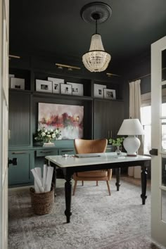 a living room filled with furniture and a chandelier hanging from the ceiling over a table