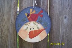 a ceramic ornament hanging on a wooden fence