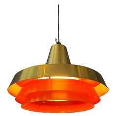 an orange and yellow light hanging from a ceiling fixture on a white background with clippings