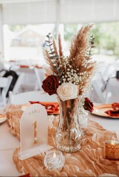 a vase filled with flowers sitting on top of a table next to a number one sign