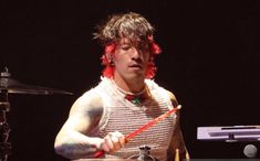 a man with red hair playing drums on stage