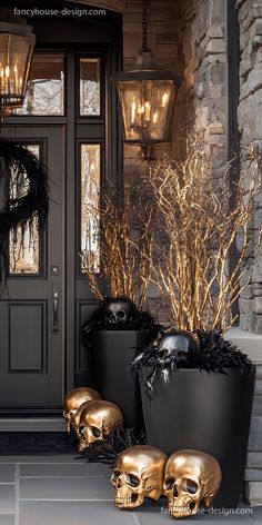 two gold skulls are sitting in front of a black door and some plants with golden leaves