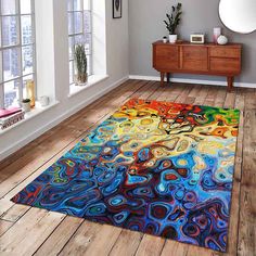 a colorful area rug in a room with wooden floors and windows on the side wall